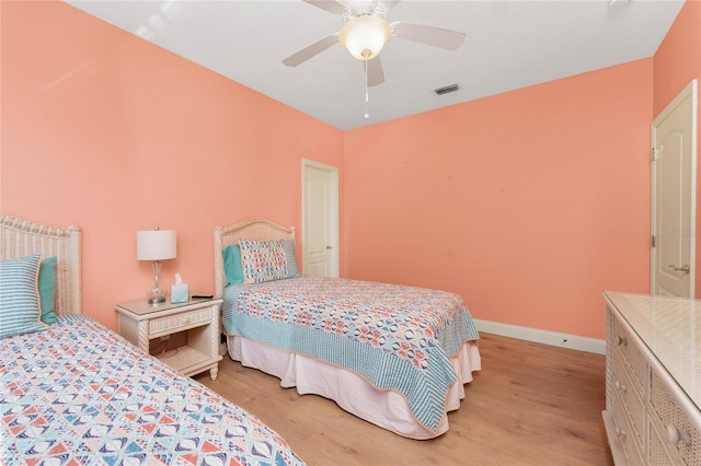 bedroom featuring a ceiling fan, baseboards, visible vents, and light wood finished floors