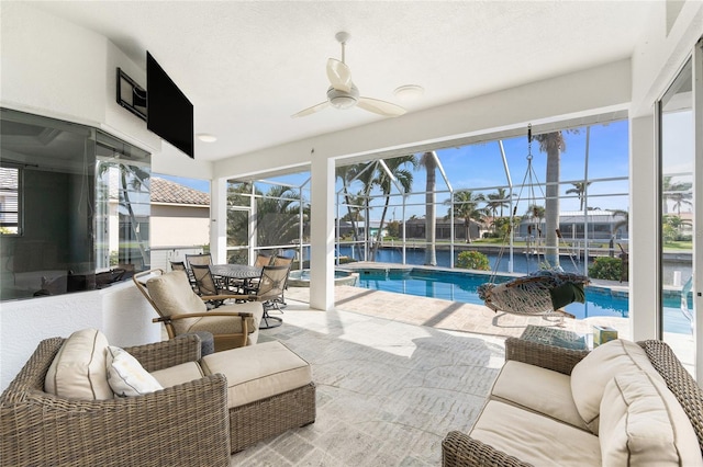 sunroom with ceiling fan and a swimming pool