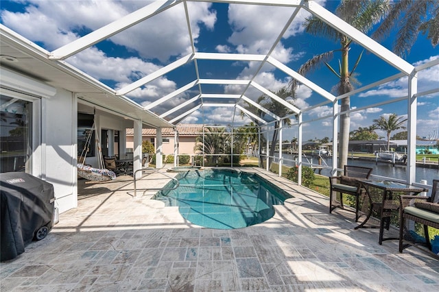 view of pool featuring a patio area, a pool with connected hot tub, glass enclosure, and area for grilling