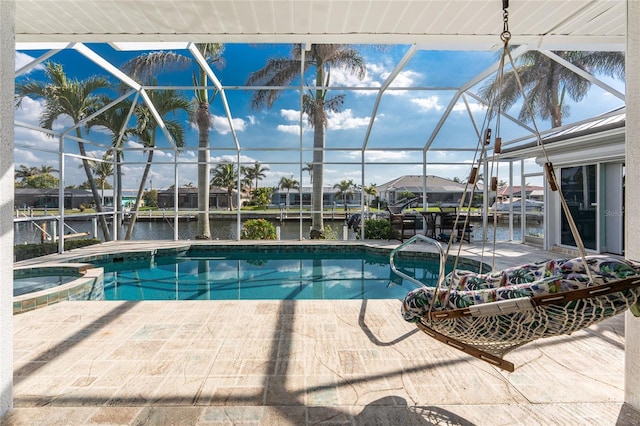 view of pool featuring a patio area, glass enclosure, and a pool with connected hot tub