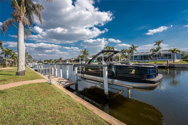 view of dock featuring a yard, a water view, and boat lift