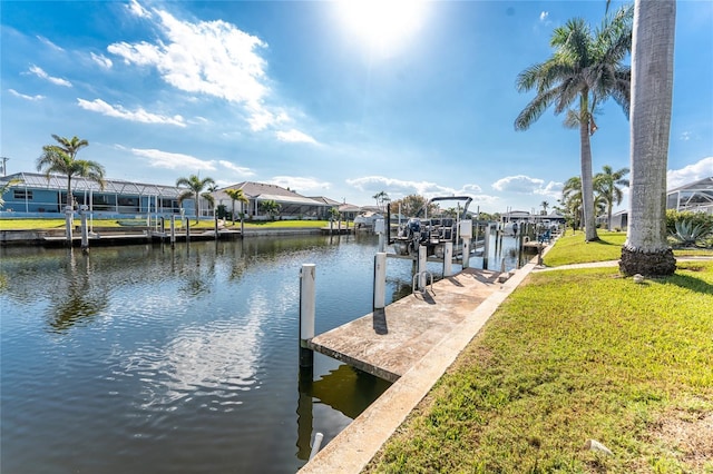 view of dock featuring a water view, boat lift, a residential view, and a yard