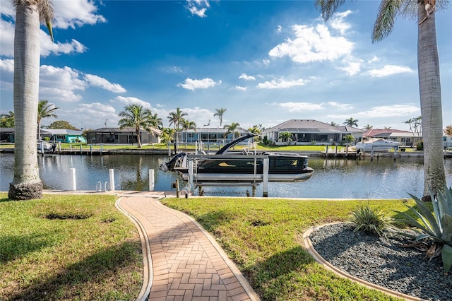 dock area featuring a residential view, a lawn, and boat lift