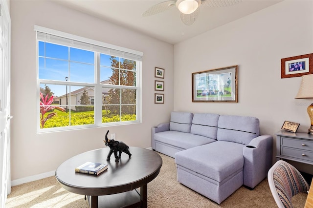 living area featuring carpet floors, a ceiling fan, and baseboards