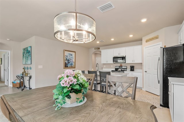 dining area featuring recessed lighting, visible vents, arched walkways, a notable chandelier, and light tile patterned flooring