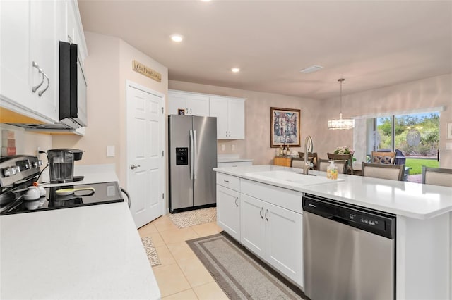 kitchen featuring stainless steel appliances, light countertops, white cabinets, a sink, and a chandelier