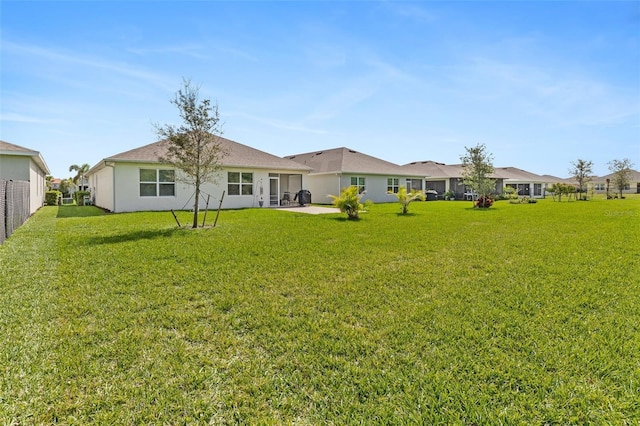 back of property with a patio area, a yard, and fence