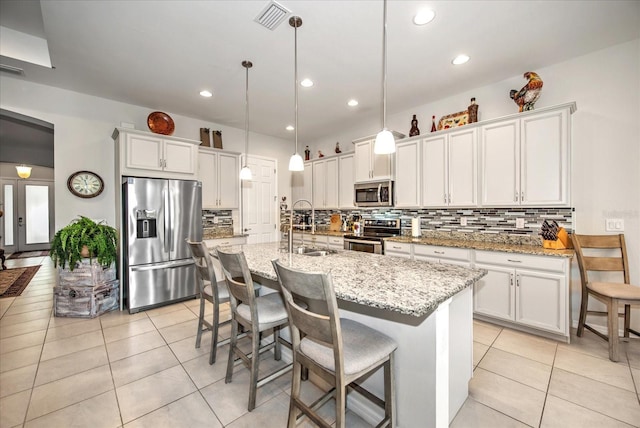 kitchen with light tile patterned floors, visible vents, appliances with stainless steel finishes, white cabinetry, and a sink