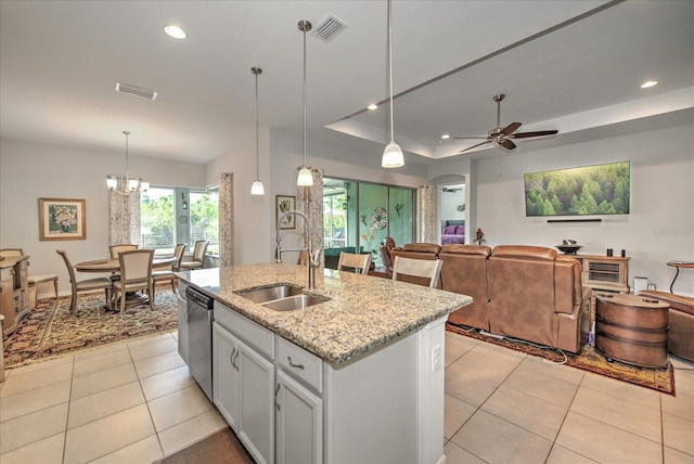 kitchen with a raised ceiling, visible vents, open floor plan, light tile patterned flooring, and dishwasher