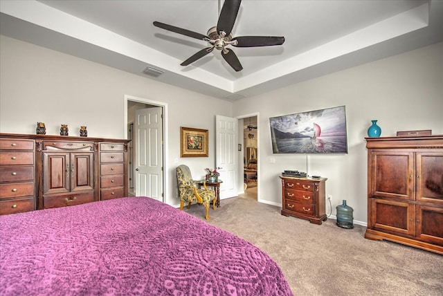 bedroom featuring baseboards, visible vents, a ceiling fan, a raised ceiling, and carpet flooring