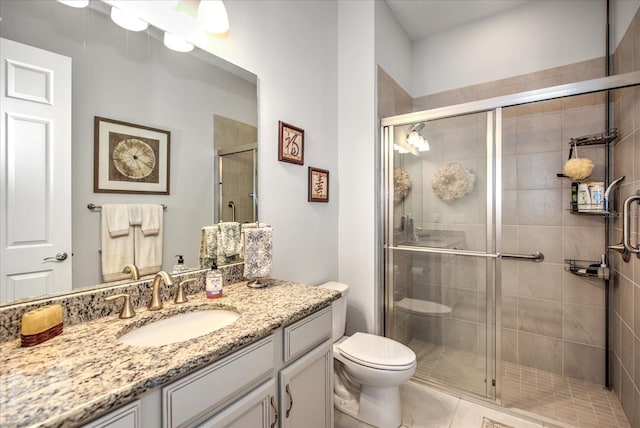 bathroom featuring vanity, a shower stall, and toilet