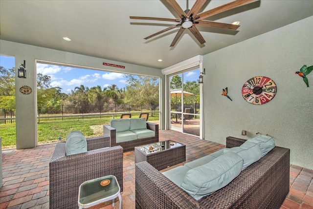 view of patio / terrace with fence, an outdoor living space, and ceiling fan