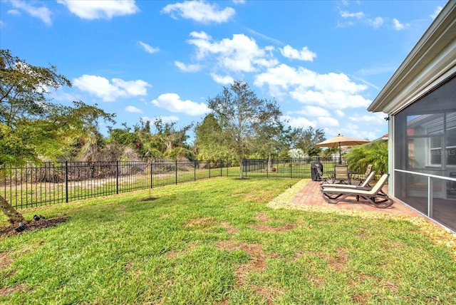 view of yard with a patio, a fenced backyard, and a sunroom