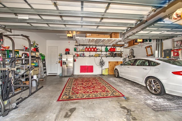 garage with stainless steel fridge and a garage door opener