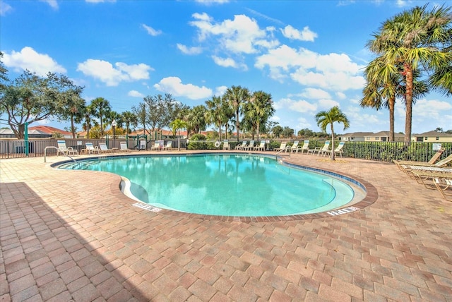 pool with a patio and fence