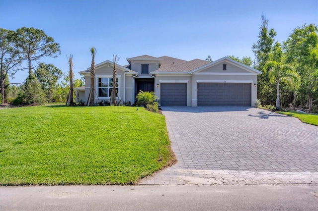 view of front of property with a garage, a front lawn, and decorative driveway