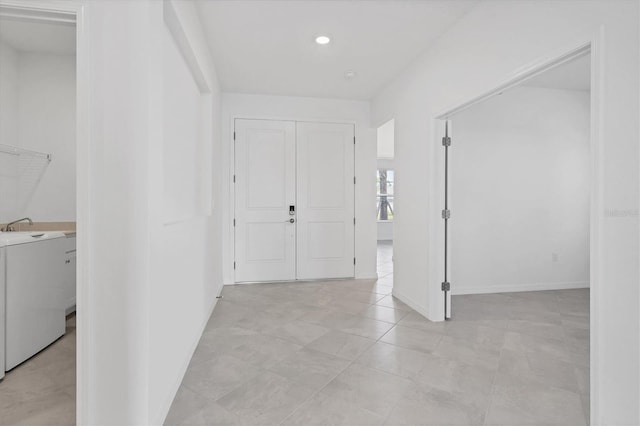 foyer entrance featuring washer / dryer and baseboards