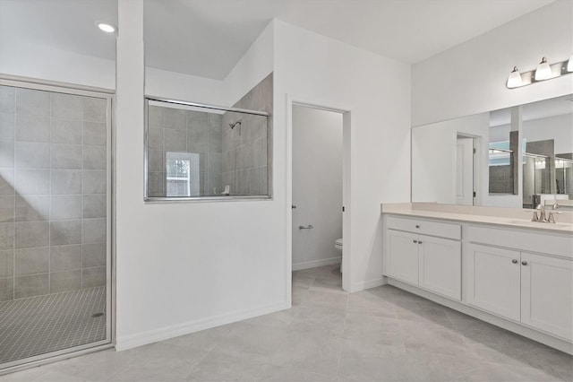 full bath featuring a stall shower, vanity, toilet, and baseboards