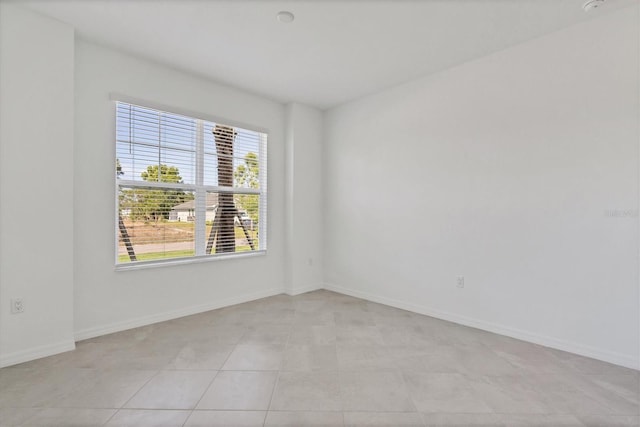 unfurnished room with baseboards