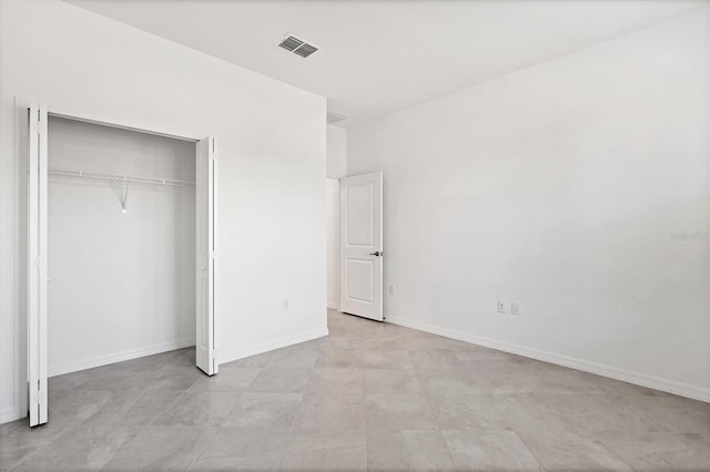 unfurnished bedroom featuring a closet, visible vents, and baseboards