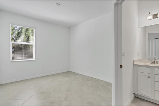 empty room with a sink and baseboards