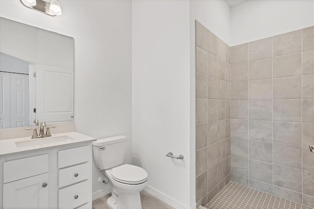 full bath with toilet, baseboards, a tile shower, and vanity