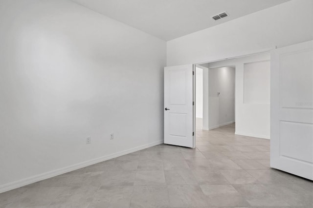 unfurnished room with visible vents and baseboards