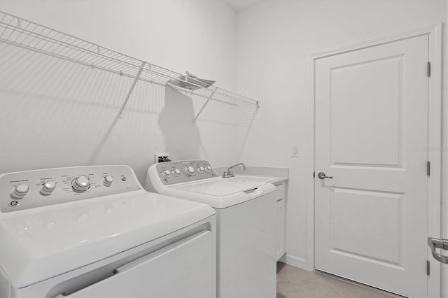 laundry room with washer and dryer, cabinet space, a sink, and light tile patterned floors