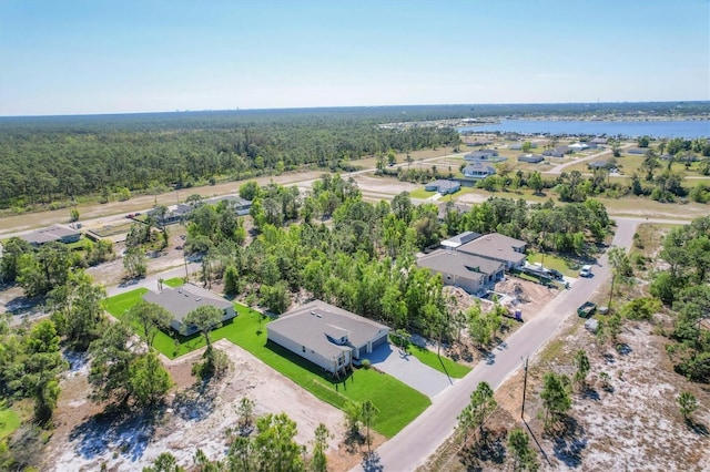 birds eye view of property featuring a water view and a view of trees