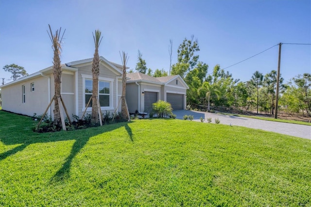 ranch-style house with driveway, a front lawn, and an attached garage