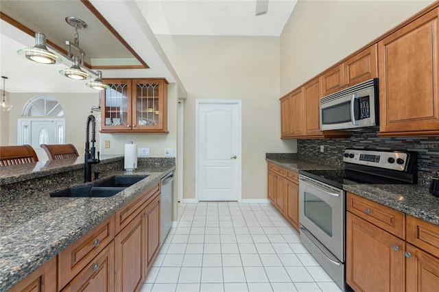 16571 Cape Horn Blvd, Punta Gorda, FL 33955 - kitchen with glass insert cabinets, decorative backsplash, brown cabinets, stainless steel appliances, and a sink