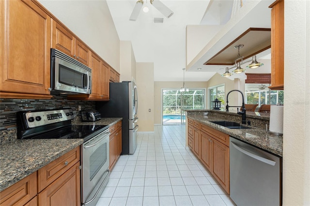 16571 Cape Horn Blvd, Punta Gorda, FL 33955 - kitchen with light tile patterned flooring, a sink, appliances with stainless steel finishes, brown cabinets, and backsplash