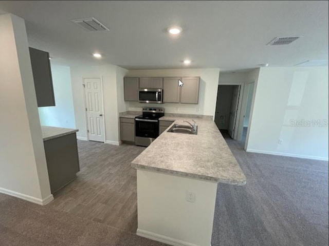 kitchen featuring visible vents, stainless steel appliances, a sink, and gray cabinetry