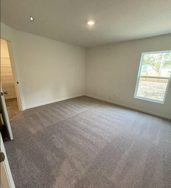 carpeted spare room featuring recessed lighting and baseboards