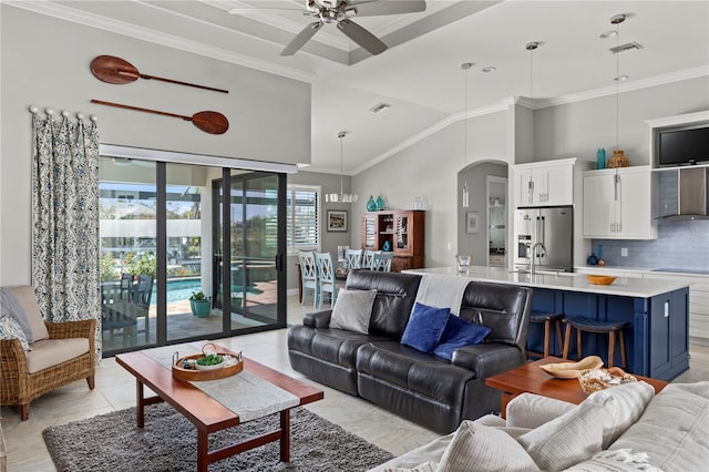 living room with high vaulted ceiling, visible vents, arched walkways, and crown molding