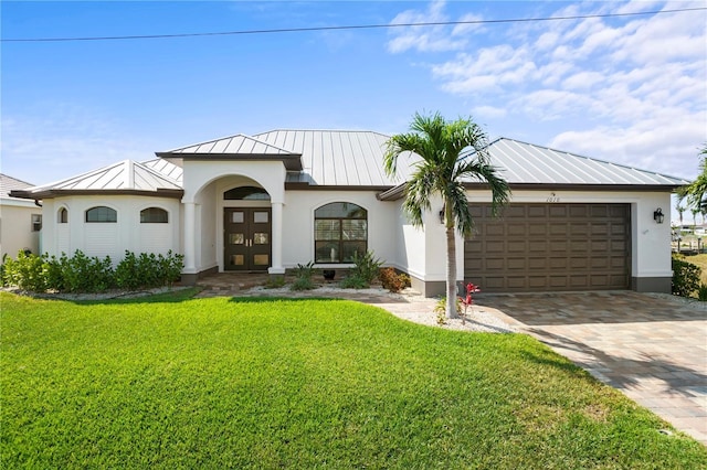 view of front of house with metal roof, an attached garage, french doors, decorative driveway, and a standing seam roof