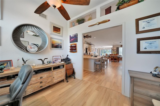 office area with baseboards, a ceiling fan, visible vents, and light wood-style floors