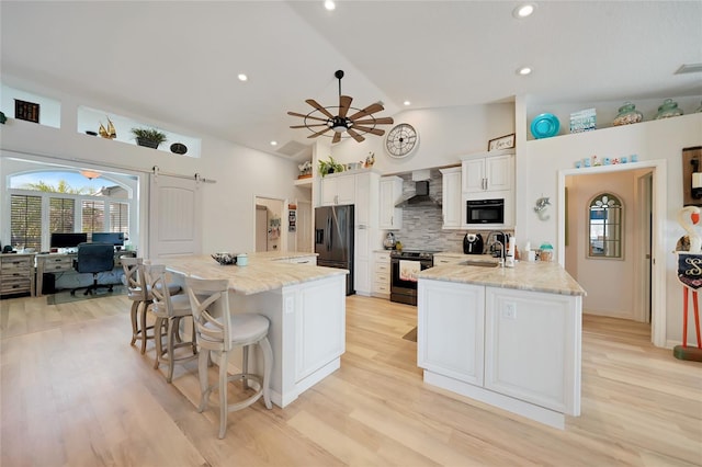 kitchen featuring electric stove, black refrigerator with ice dispenser, wall chimney range hood, and a center island with sink