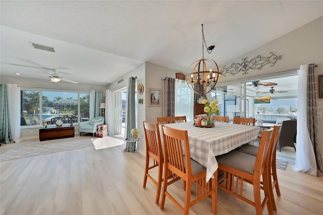 dining area with vaulted ceiling, visible vents, plenty of natural light, and light wood-style flooring