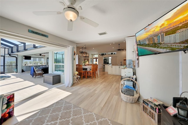 interior space with a ceiling fan, visible vents, and light wood-style floors