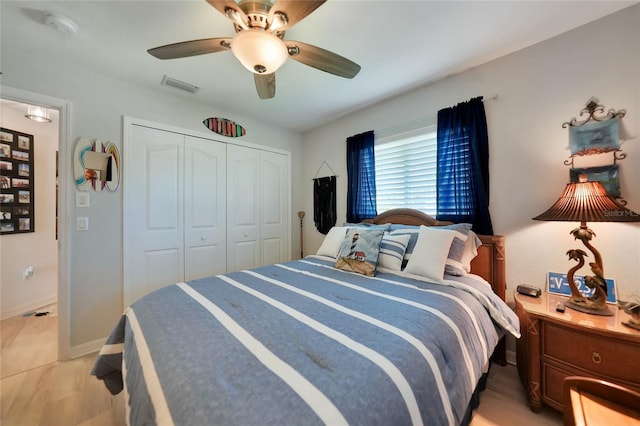 bedroom with a ceiling fan, a closet, visible vents, and baseboards