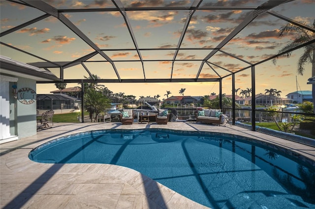 pool at dusk featuring a residential view, glass enclosure, a patio area, and an outdoor pool