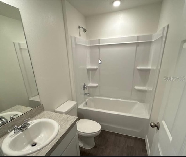 full bath with shower / bathtub combination, vanity, wood finished floors, and toilet