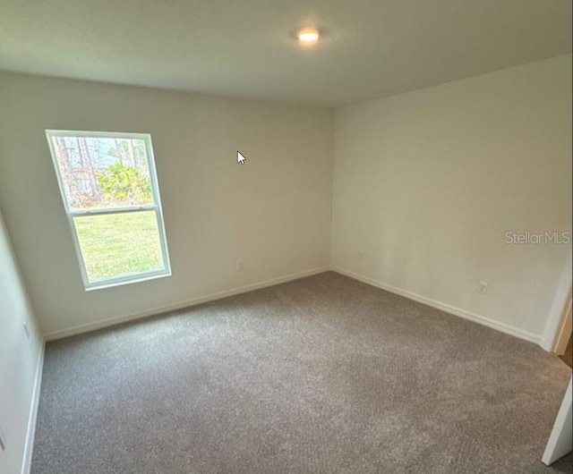 carpeted empty room with baseboards