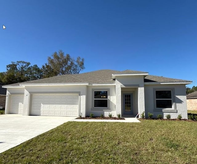 view of front of property featuring a garage, driveway, a front yard, and stucco siding