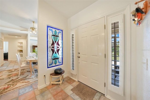 entrance foyer featuring ceiling fan and baseboards