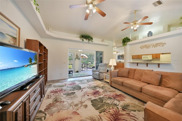 living area with high vaulted ceiling, visible vents, and a ceiling fan