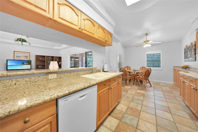 kitchen featuring baseboards, a ceiling fan, dishwasher, light stone counters, and a sink