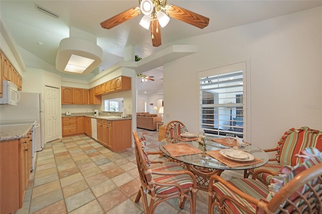 dining area with a ceiling fan, lofted ceiling, and visible vents