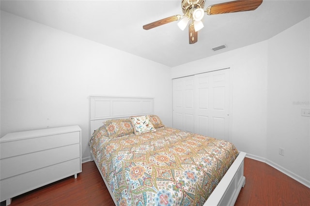 bedroom with dark wood-style floors, a closet, visible vents, and a ceiling fan